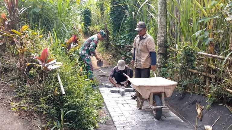 Semangat Kebersamaan! Babinsa Dadapan Bantu Warga Pasang Paving Blok Jalan Dusun
