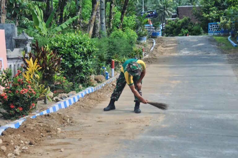 Satgas TMMD Kodim 0818 Bersihkan Jalan Raya di Lokasi Pipanisasi Desa Lebakharjo.